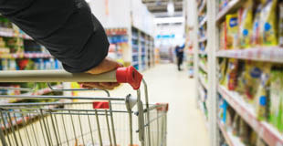 Picture of a person pushing a grocery cart down a shopping aisle